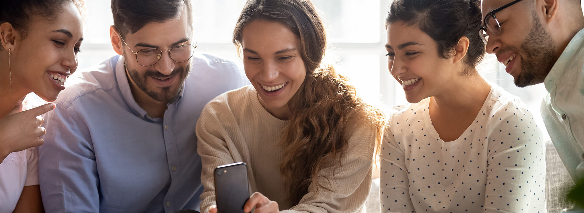 group of people smiling at a phone